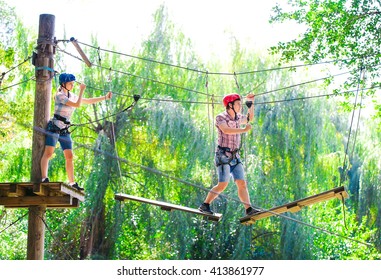 adventure climbing high wire park - people on course in mountain helmet and safety equipment - Powered by Shutterstock