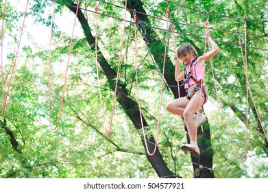 adventure climbing high wire park - hiking in the rope park girl in safety equipment - Powered by Shutterstock