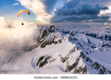 Adventure Composite Image of Paraglider Flying up high in the Rocky Mountains. Sunny Sunset Sky. Aerial Background from Squamish, British Columbia, Canada. Extreme Sport Concept