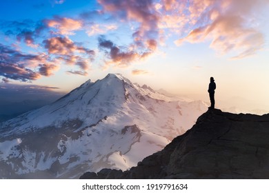 Adventure, Explore and Lifestyle Concept Composite. Adventurous Man Hiker on top of a Steep Rocky Cliff. Sunset or Sunrise. Landscape Taken from Washington, USA. - Powered by Shutterstock