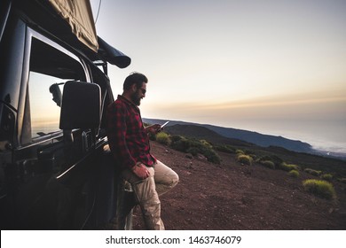 Adventure Explorer Traveler Man Use Cellular Phone With Internet Connection In Wild Mountain Place During Travel Excursion With Off Road Black Car And Tent On The Roof - Free People Concept