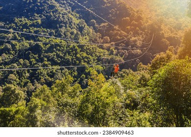 Adventure and extreme sports concept, hanging on a rope in the mountains on zip line  on mountain background. Mountain climbing sport. - Powered by Shutterstock