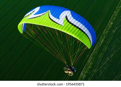 liberté d'aventure: vue aérienne d'un parapente motorisé bleu et vert survolant les champs de la région Ile-de-France, France