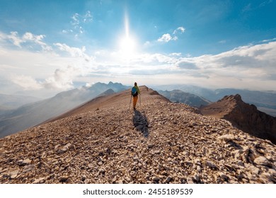 Adventure in the mountains. mountaineering and rock climbing. Hiking in the mountains. A girl with a backpack walks along a mountain path. concept of freedom and adventure. Girl in the mountains - Powered by Shutterstock