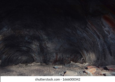 Adventure spelunking in deep dark cave with bright blue, red, and purple neon lights lighting up the cave. Hikers explore a cave in these beautiful long exposure creepy unique cavern images. - Powered by Shutterstock