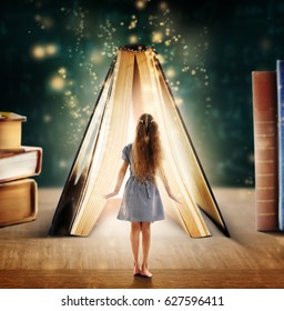 Adventure story and fairy tale. Tiny girl and book with magic glowing on table