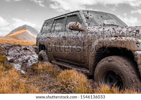 Adventure travel concept background. 4x4 off-road suv car stuck in mud. Adventure travel concept background. Offroad car.