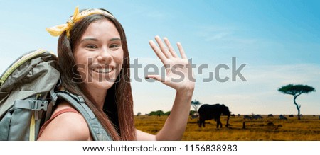 adventure, travel, tourism, hike and people concept - smiling young woman with backpack over animals in african savannah background