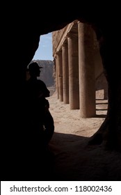 Adventurer (Indiana Jones Look) Near Old Columns In Mystery Ancient Nabatean City Petra, Jordan. Good For Book Cover, Postcards Or Adventure Equipment Advertising.