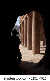 Adventurer (Indiana Jones Look) Near Old Columns In Mystery Ancient Nabatean City Petra, Jordan. Good For Book Cover, Postcards Or Adventure Equipment Advertising.