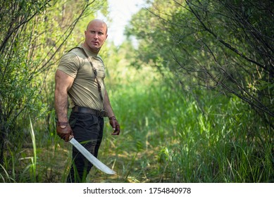 Adventurer Man With A Machete In The Green Forest Concept.