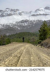 Adventurer Riding A Bike With A View Of Snowy Mountains