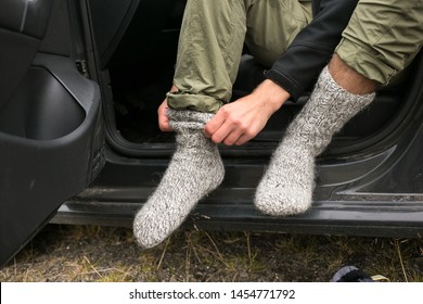 Adventurer, Touirst Or Hiking Affectionate Changes Shoes Inside Car After Or Before Long Wet Walk In Harsh Conditions. Puts On Pair Or Clean And Dry Wool Socks To Warm Up Feet In Cold Weather