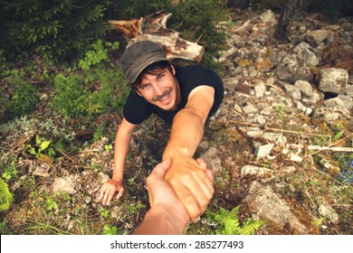 Adventurers Helping Each Other To Climb The Mountain