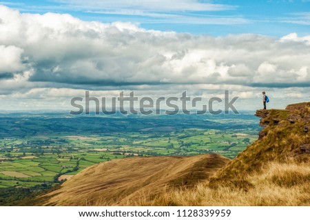
An adventurous child looking out on breathtaking scenery in the Brecon Beacons National park. Pen y Fan, Wales. United Kingdom, UK.