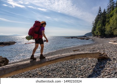 Adventurous girl hiking Juan de Fuca Trail to Chin Beach on the Pacific Ocean Coast during a sunny summer day. Taken near Port Renfrew, Vancouver Island, BC, Canada.