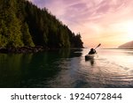 Adventurous Girl kayaking in the Pacific Ocean. Sunset Sky Art Render. Taken in San Josef Bay, Cape Scott, Northern Vancouver Island, British Columbia, Canada. Adventure Travel Concept