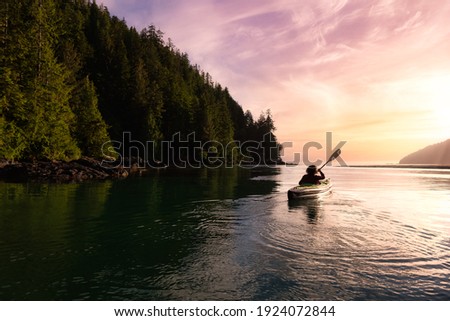 Adventurous Girl kayaking in the Pacific Ocean. Sunset Sky Art Render. Taken in San Josef Bay, Cape Scott, Northern Vancouver Island, British Columbia, Canada. Adventure Travel Concept