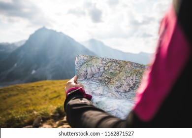 Adventurous Girl navigating in with a Topographic Map in the beautiful Mountains of the Austrian Alps - Shutterstock ID 1162871527