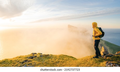Adventurous man hiker standing on the edge cliff during sunset or sunrise. Travel Lifestyle success motivation concept adventure active vacation outdoors. The boy looks ahead. - Shutterstock ID 2192737723