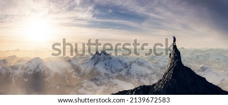 Adventurous Man Hiker standing on top of icy peak with rocky mountains in background. Adventure Composite. 3d Rendering rocks. Aerial Image of landscape from British Columbia, Canada. Sunset Sky
