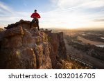 Adventurous man is rappeling down a cliff during a bright and vibrant sunny sunset. Taken in Smith Rock, Oregon, North America.