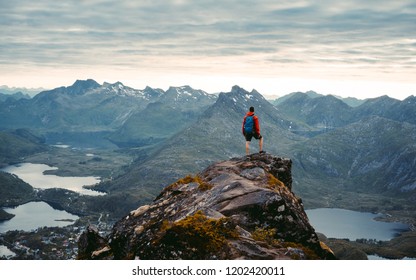 Adventurous man is standing on top of the mountain and enjoying the beautiful view during a vibrant sunset. Beautiful Nature Norway natural landscape aerial photography - Shutterstock ID 1202420011