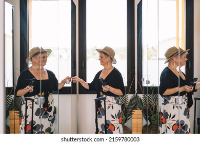 Adventurous Mature Woman, Arriving At The Hotel Room From Her Summer Holiday. Woman Unpacking Her Luggage In The Dressing Room.