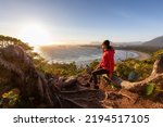 Adventurous Woman Hiker overlooking Sandy Beach on the West Coast of Pacific Ocean. Canadian Nature Landscape Background. Cox Bay Lookout, Tofino, Vancouver Island, BC, Canada.