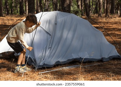 Adventurous Young Boy Setting Up Camp in the Wilderness - Shutterstock ID 2357559061