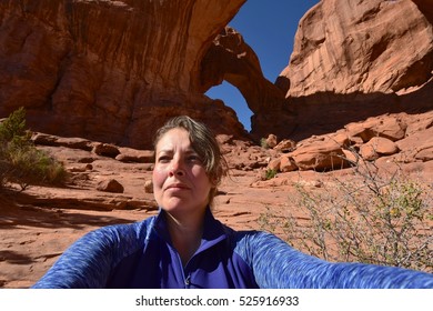 Adventurous Young Woman Hiking At Arches National Park In Utah, USA