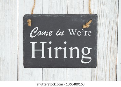 Advertise You Are Hiring With An Retro Sign, Come In We're Hiring Text On A Hanging Chalkboard On Weathered Whitewash Textured Wood