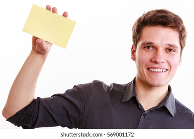 Advertisement Concept. Young Handsome Man Holding Blank Piece Of Paper. Smiling Guy Showing Empty Ad Isolated On White.