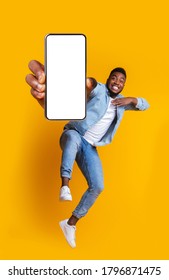 Advertisement For Mobile Application. Excited African Guy Dancing Over Yellow Background, Showing Modern Smartphone With Empty Screen, Collage