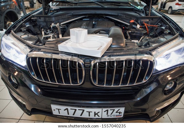advertising\
BMW cars, Moscow, 1.11.2018: Car repair and cleaning concept - car\
engine close-up, wiping parts under the\
hood