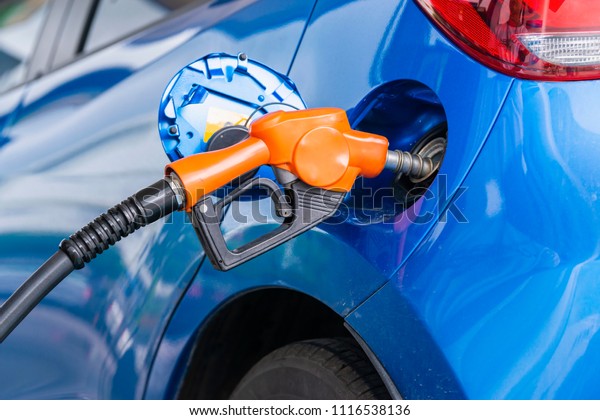 Advertising, Business, Transportation, Technology,\
Energy Concept - Fuel dispenser gas station. Blue car refueling at\
gas station. Select focus\
