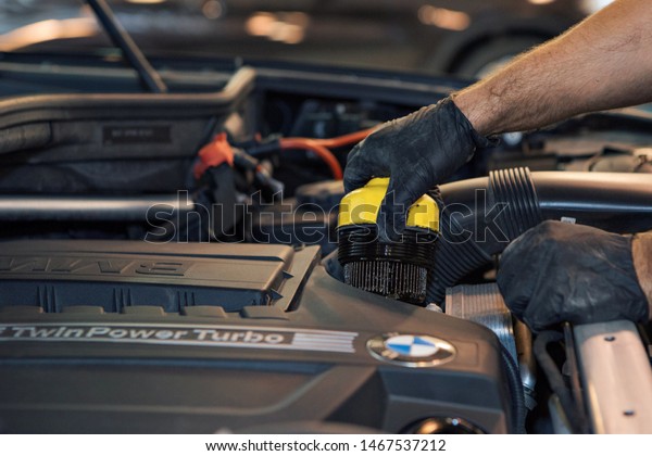 advertising car wash, Moscow, 1.11.2018: surface\
cleaning. BMW motor company badge in front of black car. German\
company. Car repair and cleaning concept - engine close-up, wiping\
parts under the\
hood