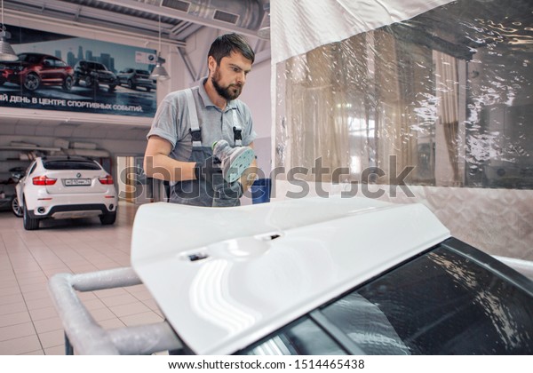 advertising car wash,\
Moscow, 1.11.2018: polishing the surface of the car. The icon of\
the BMW motor\
company