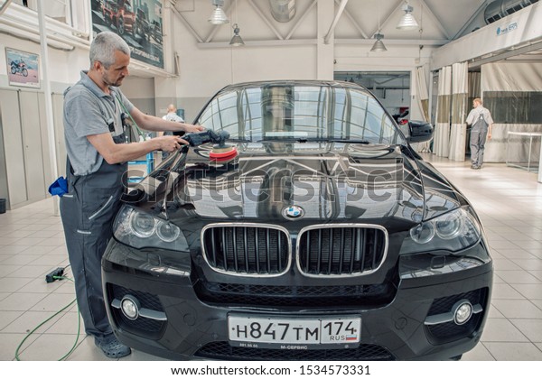 advertising car wash,\
Moscow, 1.11.2018: polishing the surface of the car. The icon of\
the BMW motor\
company
