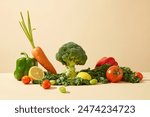 Advertising photo for product made from fresh vegetable ingredient, was taken from front angle over yellow background. Various types of organic vegetable spread evenly on table with lettuce below