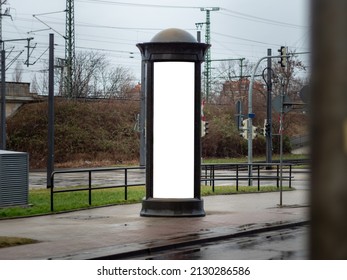 Advertising pillar in the city. Blank mockup for testing ad designs on the column next to the street. Billboard template with a white rectangle in a city. Copy space in an urban area for marketing.