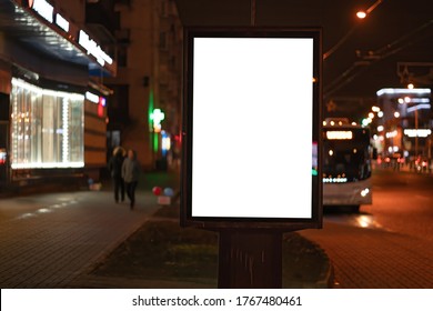 Advertising Vertical Billboard In The City Glows At Night. MOCKUP For Design