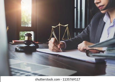 advice and justice concept. Justice scales, justice hammer and Litigation and Litigation document, female lawyer using pen point law book, working legal law with use laptop at  lawyer office.