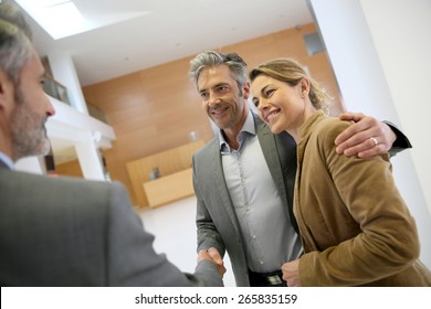 Adviser giving handshake to clients 