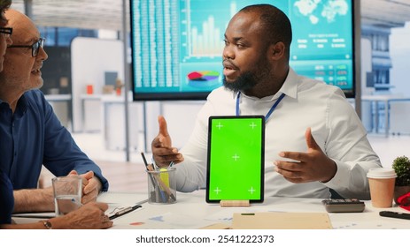 Adviser shows green screen on a tablet to middle aged people in modern office, meeting to discuss retirement and pension plan. Financial expert broker helping senior couple with finances. Camera A. - Powered by Shutterstock