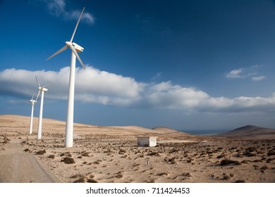 AEOLIC PARK ,WINDMILLS, WIND FARM IN SPAIN WITH BLUE SKY AND DESERT IN FUERTEVENTURA AND MALLORCA