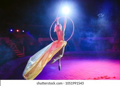 Aerial acrobat in the ring. A young girl performs the acrobatic elements in the air ring. - Shutterstock ID 1051991543