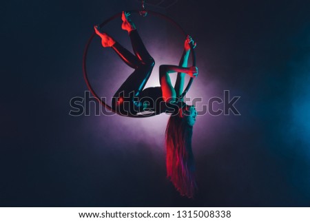 Aerial acrobat in the ring. A young girl performs the acrobatic elements in the air ring.