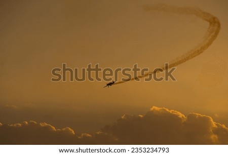 Aerial acrobatics airshow. Ultra light airplanes doing acrobatics in air against amazing sunset sky. Aviation industry concept image.