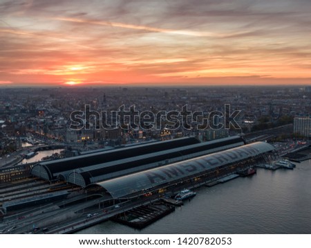 Aerial of the Amsterdam central railway station with historic city center at sunset
